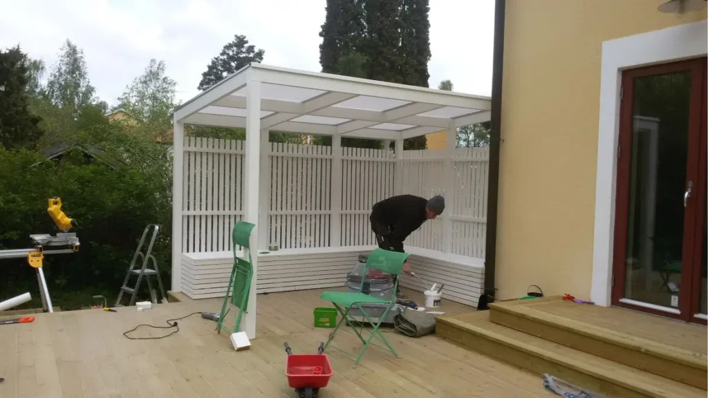 alt="Białe zadaszenie tarasu z ażurową zabudową boczną – montaż w Rzeszowie i okolicach"