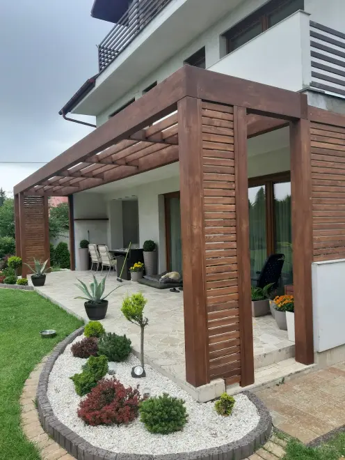 alt="Nowoczesna pergola z drewna jako zadaszenie tarasu ogrodowego"