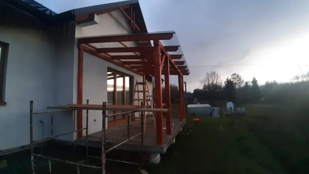 alt="montaż zadaszenia tarasu z konstrukcji drewnianej i szkła hartowanego – Rzeszów i okolice"